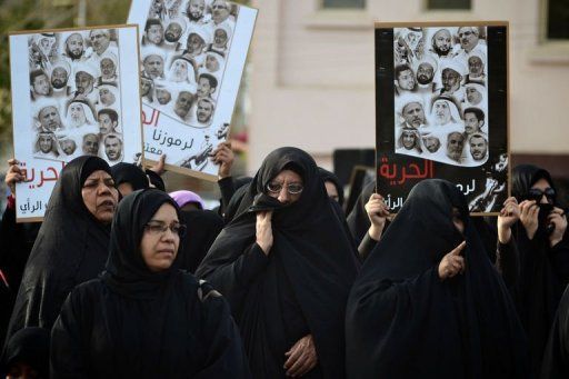 bahrain protests with hijab holding list of dead photos