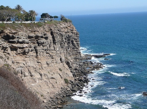 Rock cliff on wavy shoreline