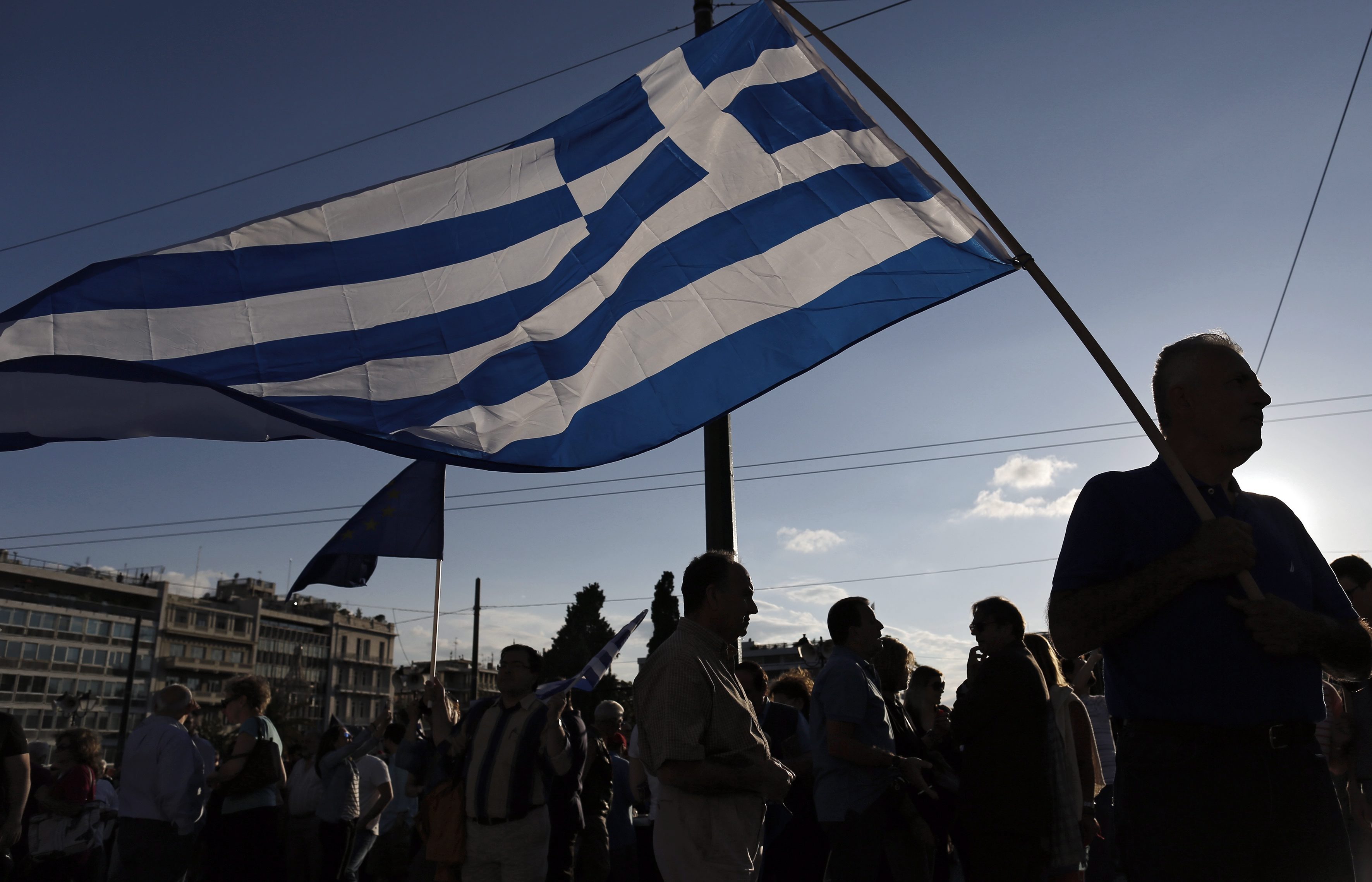 epaselect epa04814594 Protesters holds Greek flags outside the parliament during a rally demanding that Greece remains in the Eurozone, in Athens, Greece, 22 June 2015. The Eurozone's 19 national leaders hold an emergency summit in Brussels to discuss the crisis. Fears are mounting that Greece is about to run out of money, with the country facing a 1.6-billion-euro IMF repayment deadline on June 30. EPA/YANNIS KOLESIDIS